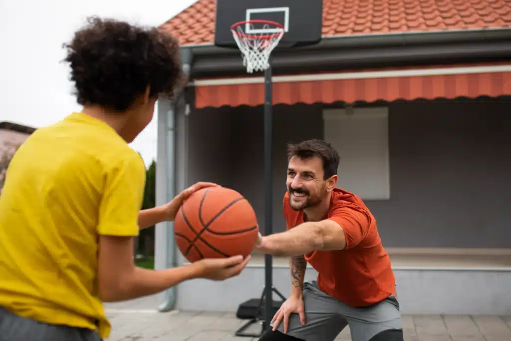 father son playing basketball together backyard